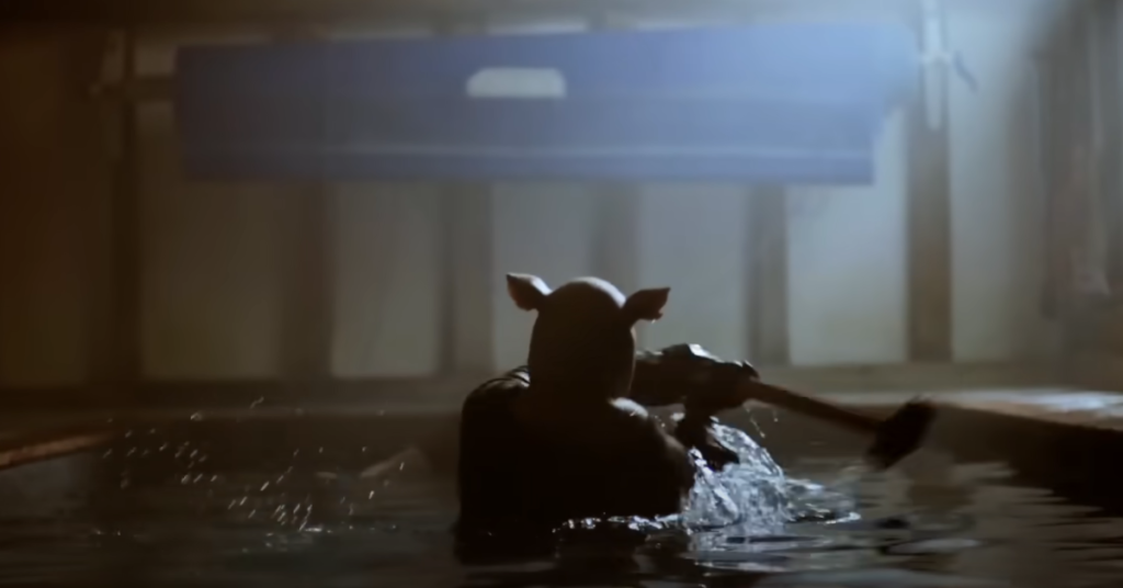 Leitão do filme Ursinho Pooh Sangue e Mel com um martelo na mão